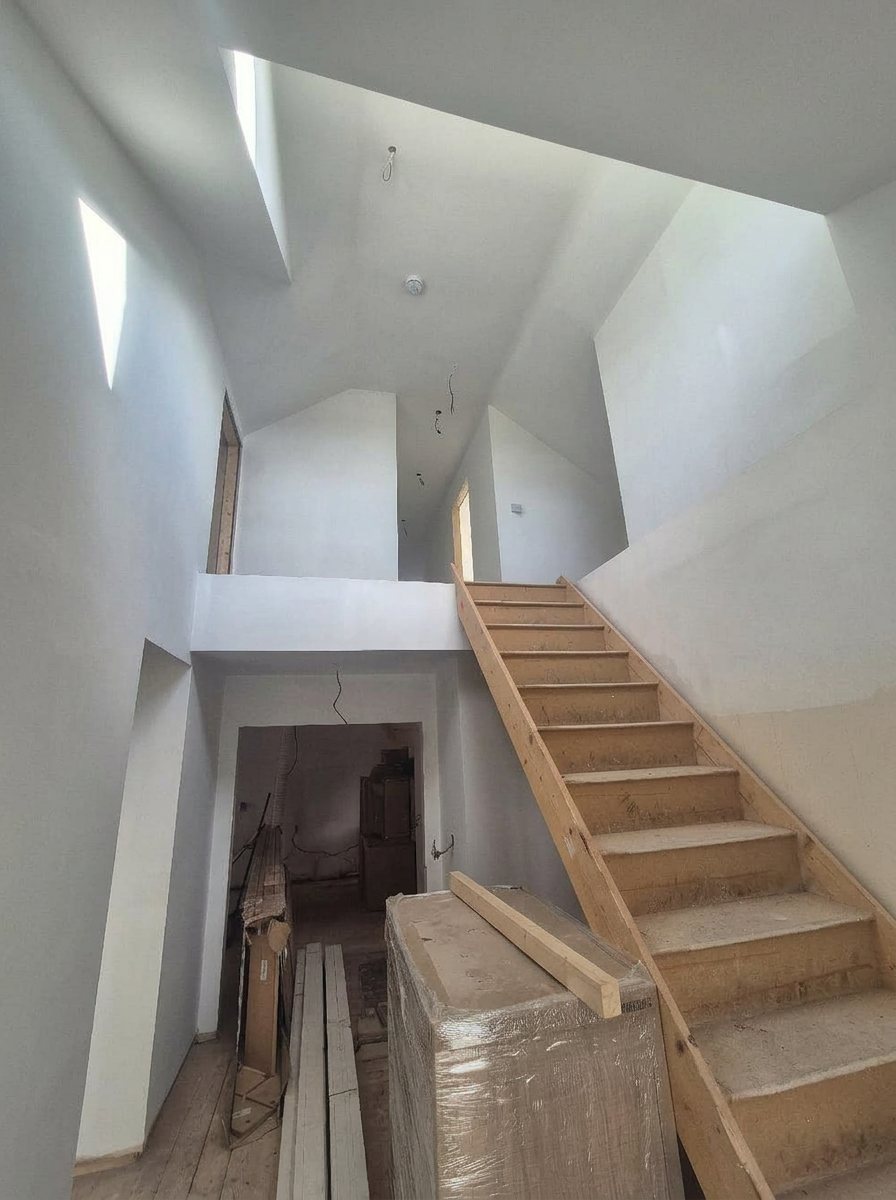 Staircase under remodelling with bare timber treads and unfinished hall